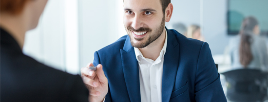 A man in a blue suit smiling for the camera.